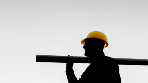 construction worker carrying pole